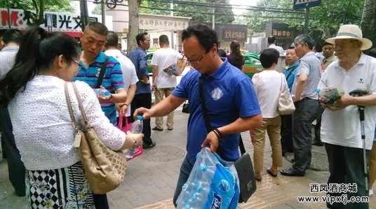 工作人员为等候在场外的家长送水
