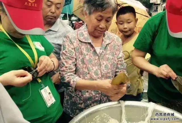 西凤酒厂工人与志愿者包粽子比赛